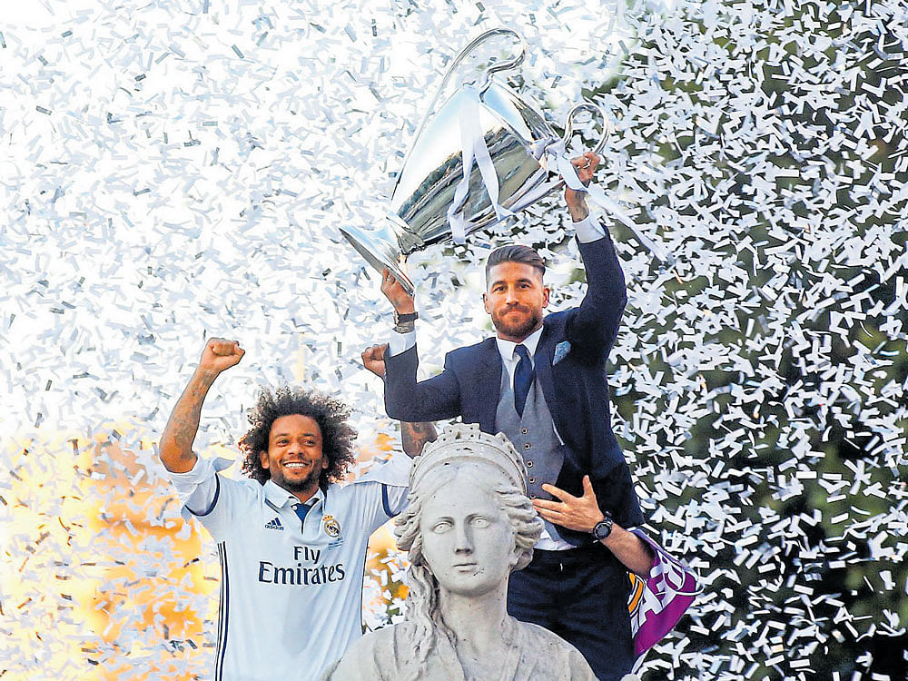 Victory parade: Real Madrid's Sergio Ramos (right) celebrates with the trophy along with Marcelo on Sunday. AFP