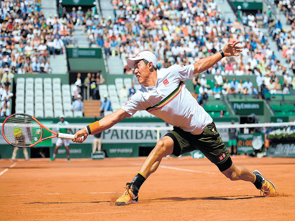 stretched: Japan's Kei Nishikori returns during his win over Fernando Verdasco of Spain in the fourth round of the French Open on Monday. AFP