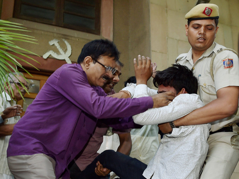 Police take away a Hindu Sena activist who was raising slogans and trying to disrupt CPI(M) general secretary Sitaram Yechury's press briefing at the party headquarters in New Delhi on Wednesday. PTI Photo