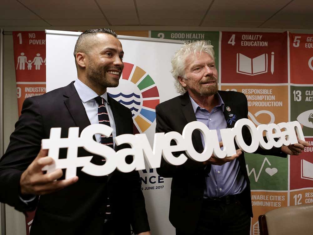Sir Richard Branson (R) poses for a picture with journalist Sherwin Bryce-Pease after delivering over 1 million signatures urging governments to protect 30 percent of the ocean by 2030 at the Ocean Conference at the United Nations in New York City, U.S., June 8, 2017. REUTERS