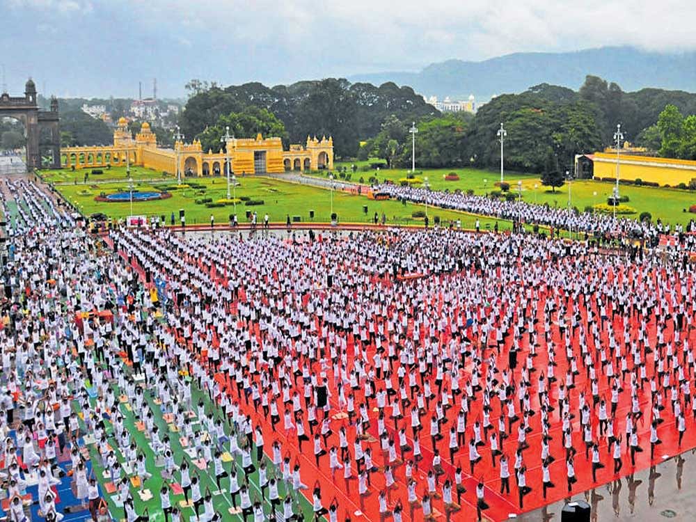the Central government will open yoga parks so people can learn more about the exercise. file photo of Yoga day at Mysore palace.