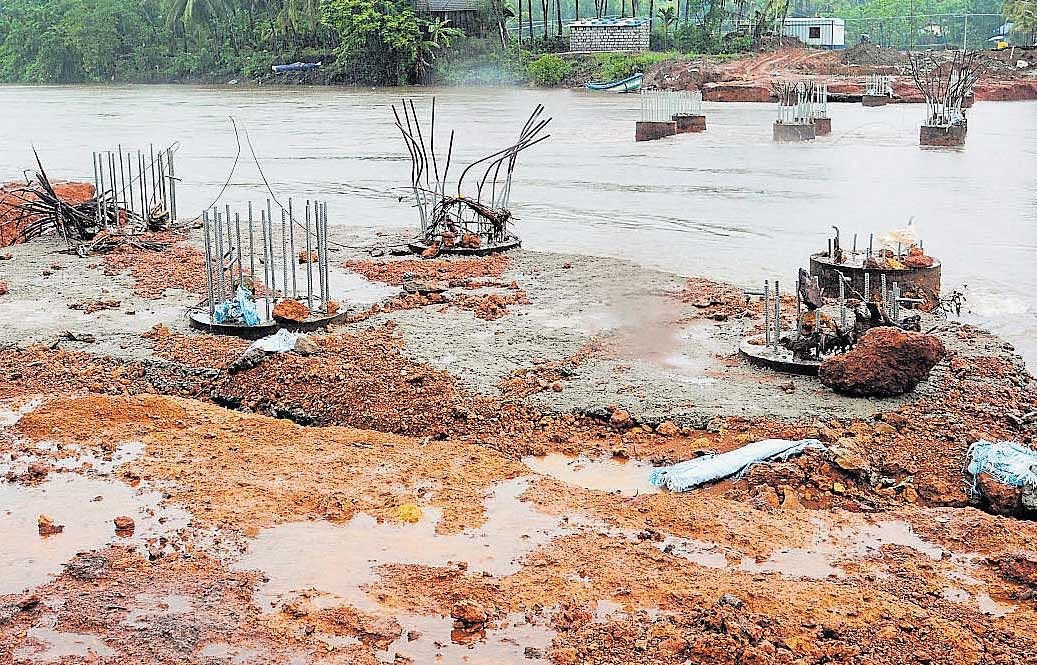 Materials being used for the construction of a bridge across the Swarna River in Udupi district were washedaway in the rain on Sunday. DH PHOTO