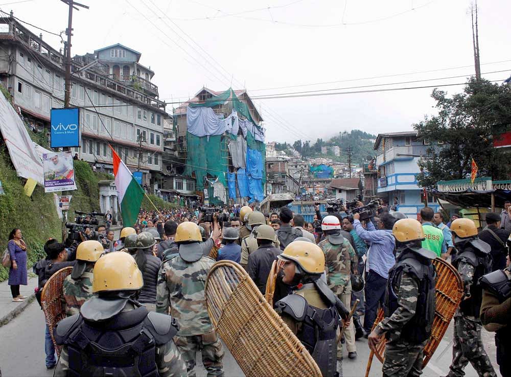 Security personnel stand guard during a protest by Gorkha Janmukti Morcha in Darjeeling Hills on Tuesday over West Bengal government's decision to teach Bengali in all schools. PTI Photo