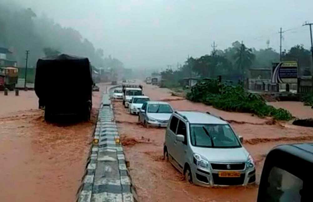 Vehicles wade through water logging National Highway in Guwahati after heavy showers on Tuesday. PTI Photo