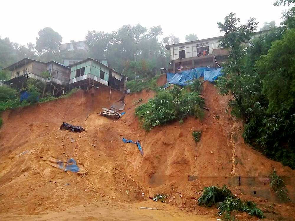 The earth under the buildings caves in after heavy rains triggered landslides in Aizawl, Mizoram on Tuesday. PTI Photo