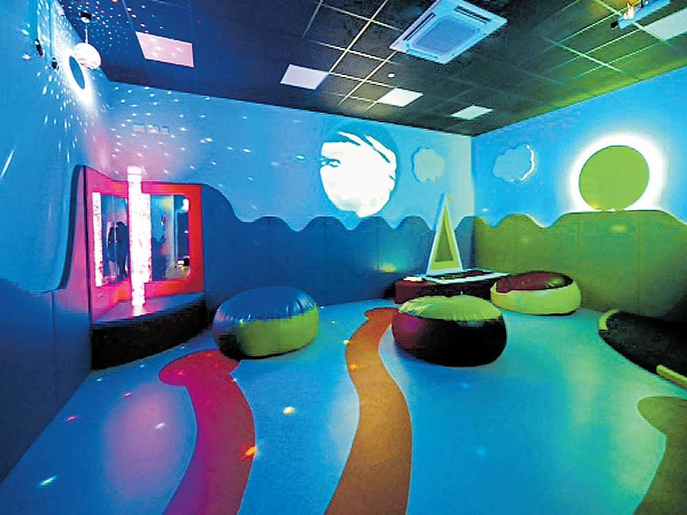 happy place: The new Sensory Room at Ireland's Shannon Airport; it is has a wavy wall, colour-changing LED lights, bean bags etc, to soothe children with autism spectrum disorder. (inset) Orange wristbands and baseball caps given to families with ASD passengers. shannon airport
