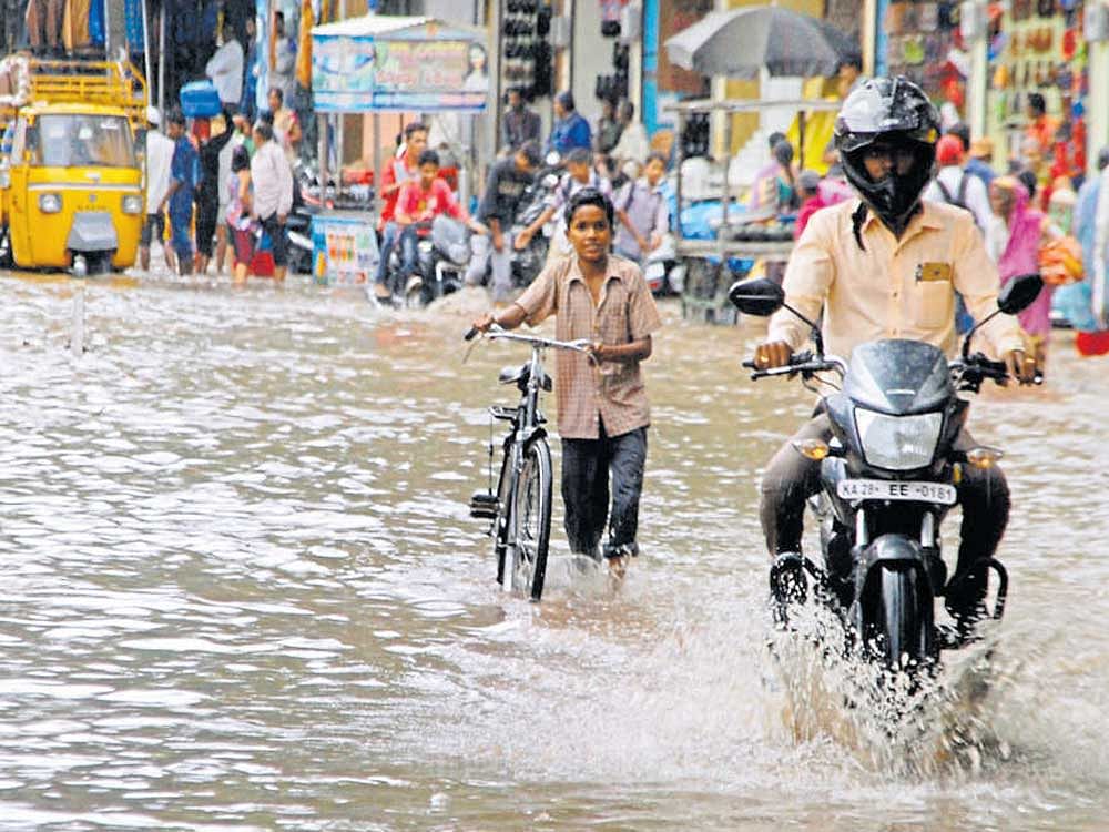 Motorists found it difficult to navigate through KC&#8200;Market Road which was inundated following heavy rainfall in  Vijayapura on Thursday. DH Photo