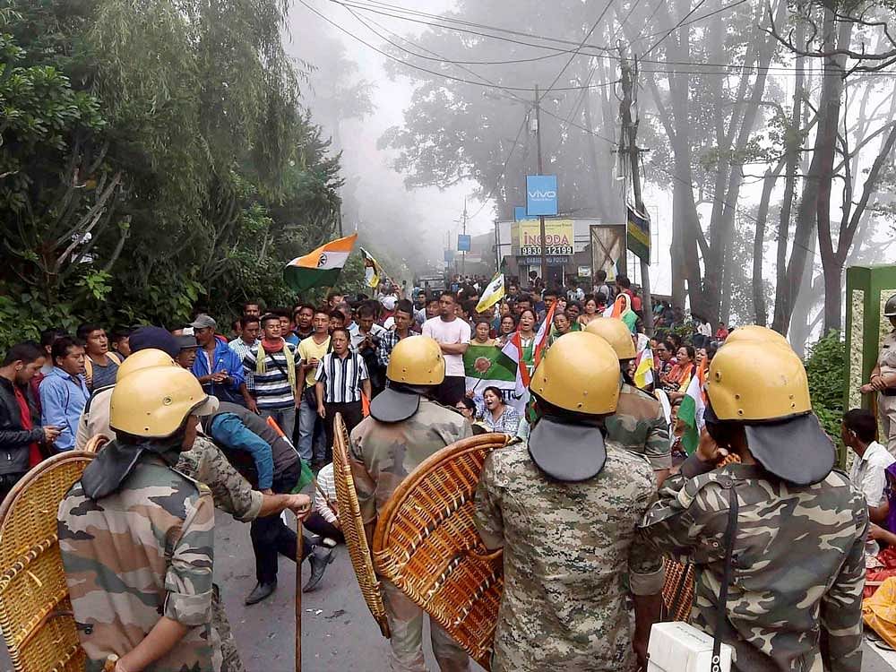 Security personnel stop Gorkha Janamukti Morcha supporters who were staging a rally in Kurseong during their Darjeeling bandh on Friday. PTI Photo.