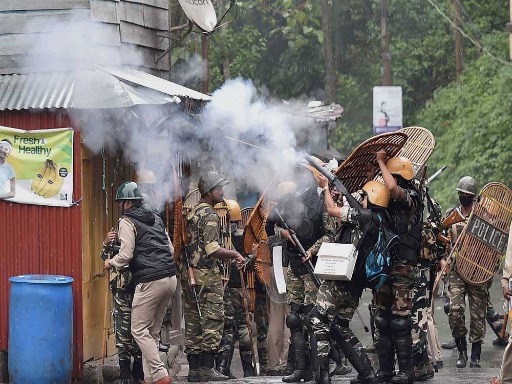Security personnel fire tear gas during a protest by Gorkha Janmukti Morcha (GJM) activists in Darjeeling on Saturday. PTI Photo