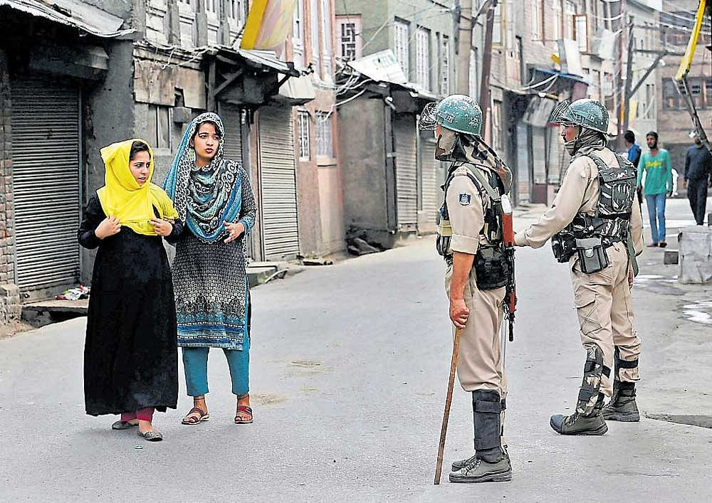 Girls seek permission from security personnel during restrictions imposed in parts of the Valley following the killing of two civilians in Srinagar on Friday. PTI