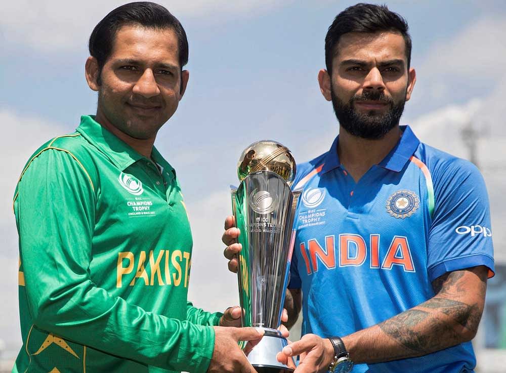 India's captain Virat Kohli, right, and Pakistan's captain Sarfraz Ahmed pose for a picture with the trophy at the Oval cricket ground in London. PTI