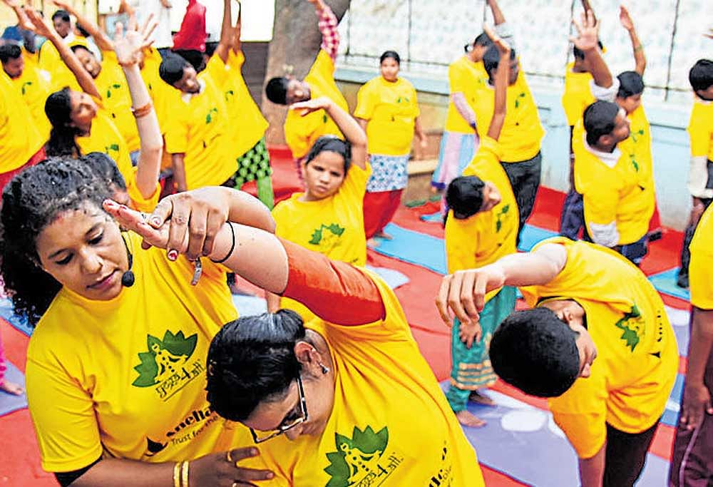 Blind students of Snehadeep Trust for Disabled perform  yoga on the eve of International Yoga Day at Cox Town on Tuesday. DH Photo