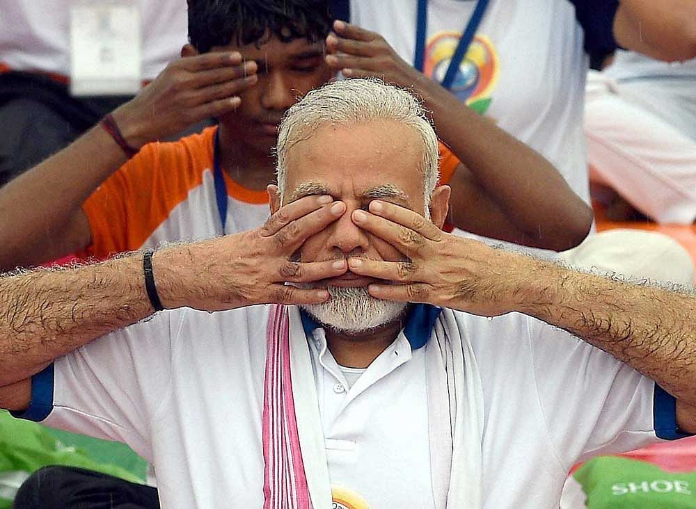 Prime Minister Narendra Modi performs yoga along with thousands of others during a mass yoga event on 3rd International Yoga Day in Lucknow, on Wednesday, June 21, 2017. PTI Photo