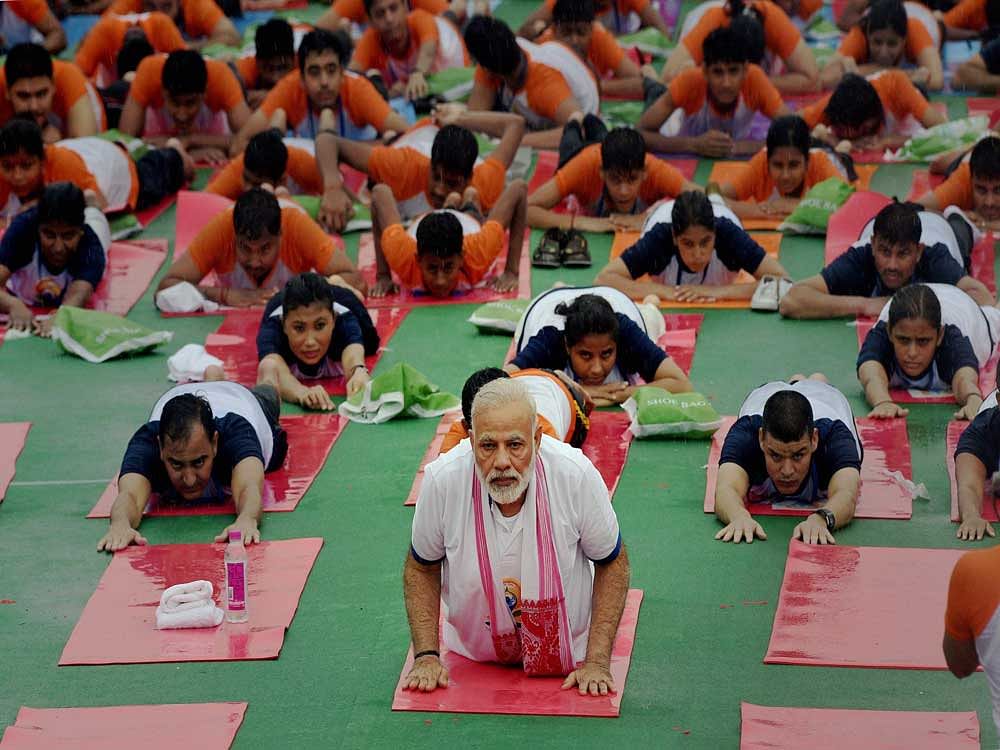 Prime Minister Narendra Modi performs yoga during a mass yoga event on 3rd International Yoga Day in Lucknow on Wednesday. PTI Photo
