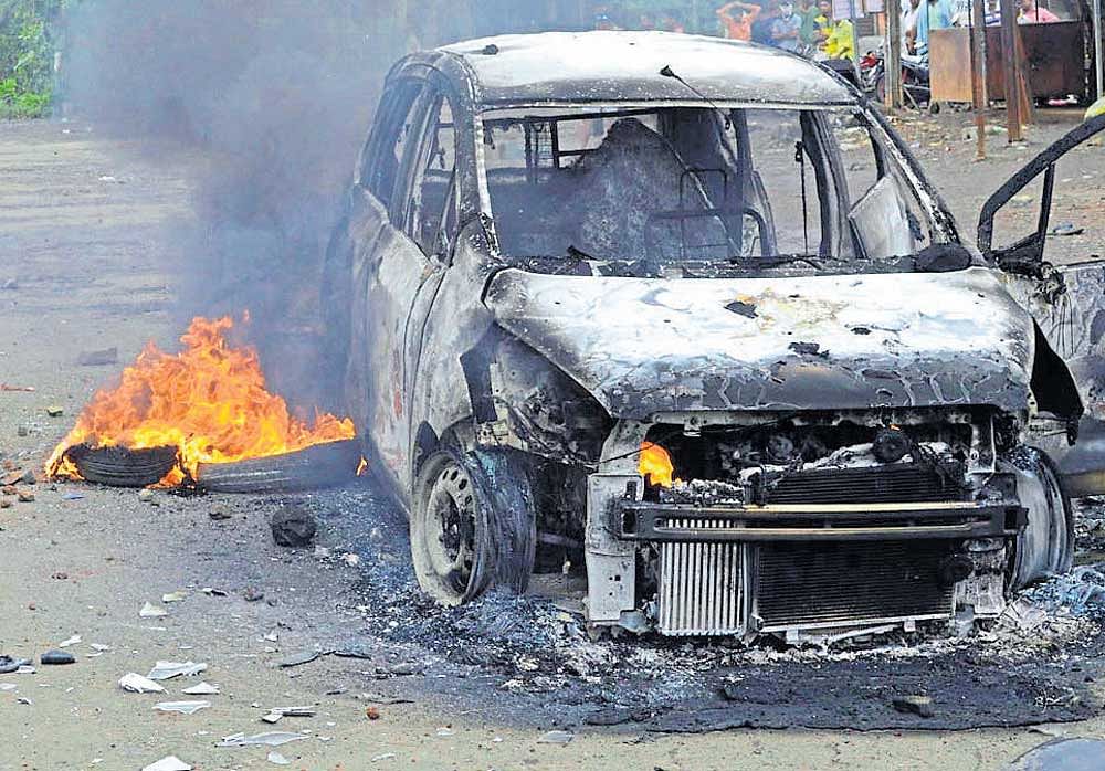 A car set ablaze by farmers during a violent protest against a proposed international airport in Thane district on Thursday. DH photo