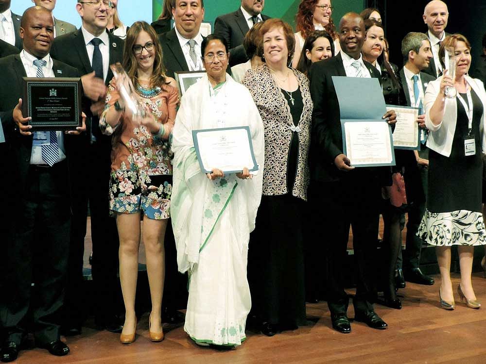 West Bengal Chief Minister Mamata Banerjee stands with others after West Bengal won an award for 'Kanyasree Prakalpa' during an event of United Nations in Netherland on Friday.PTI Photo