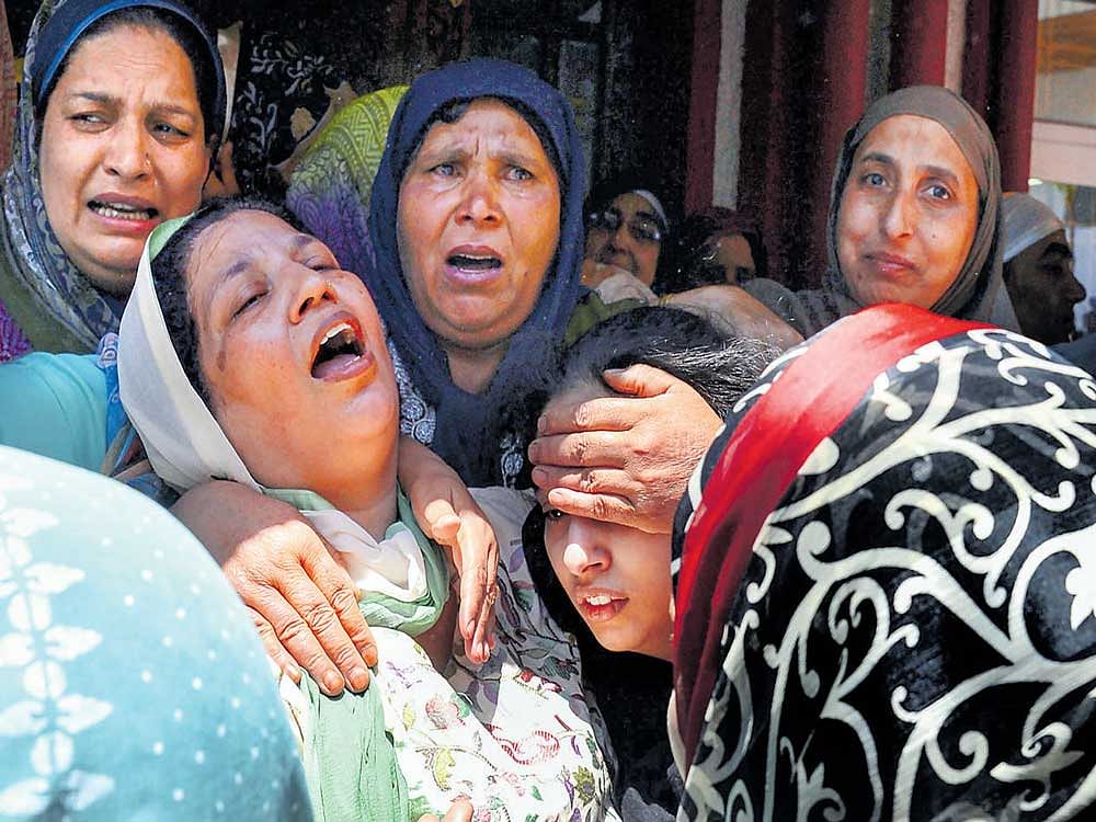 inconsolable family: The wife (2nd L) and daughter (2nd R) of slain police officer  Mohammad Ayub Pandith mourn at his home in Srinagar on Friday. AFP