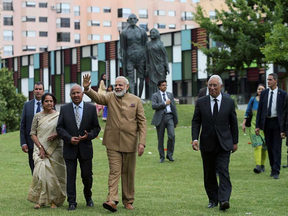 India's Prime Minister Narendra Modi waves while walking with Portuguese Prime Minister Antonio Costa, right, during a visit to the Radha Krishna Temple in Lisbon, Portugal, Saturday. AP/ PTI