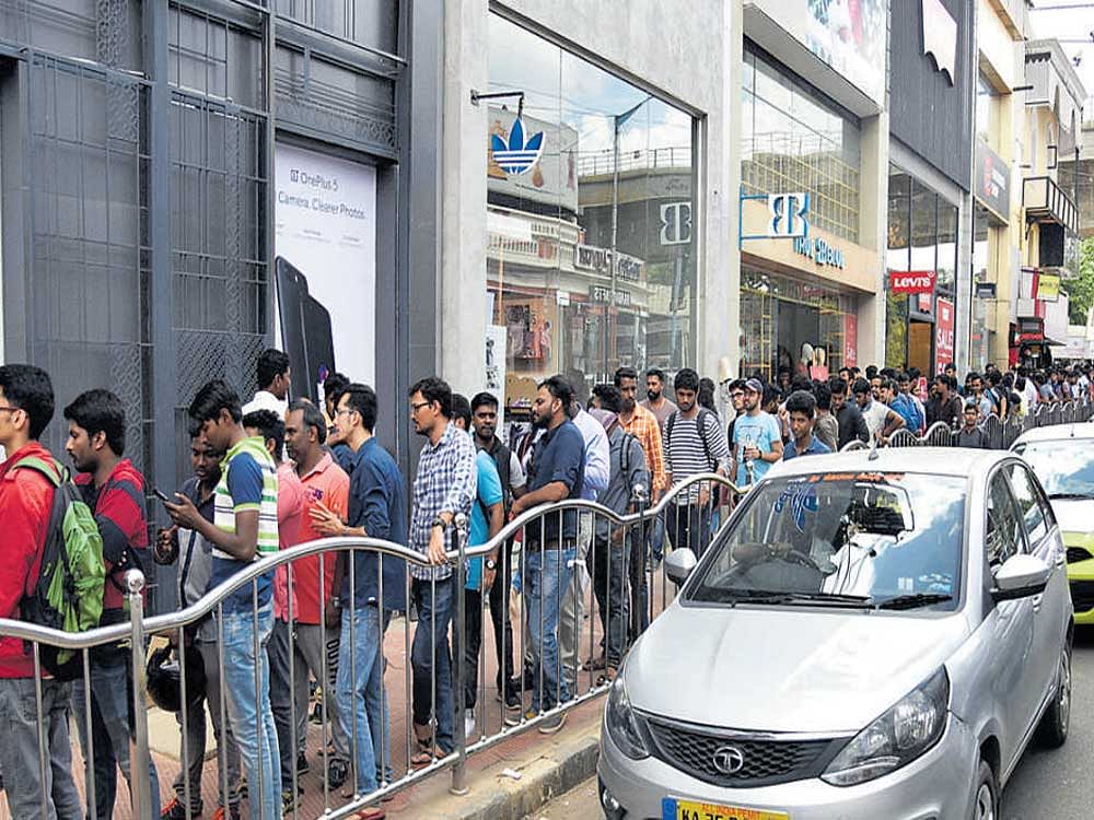Buyers queue up in front of  the One Plus mobile phone  store on Brigade Road on Saturday to lay their hands  on the latest model.