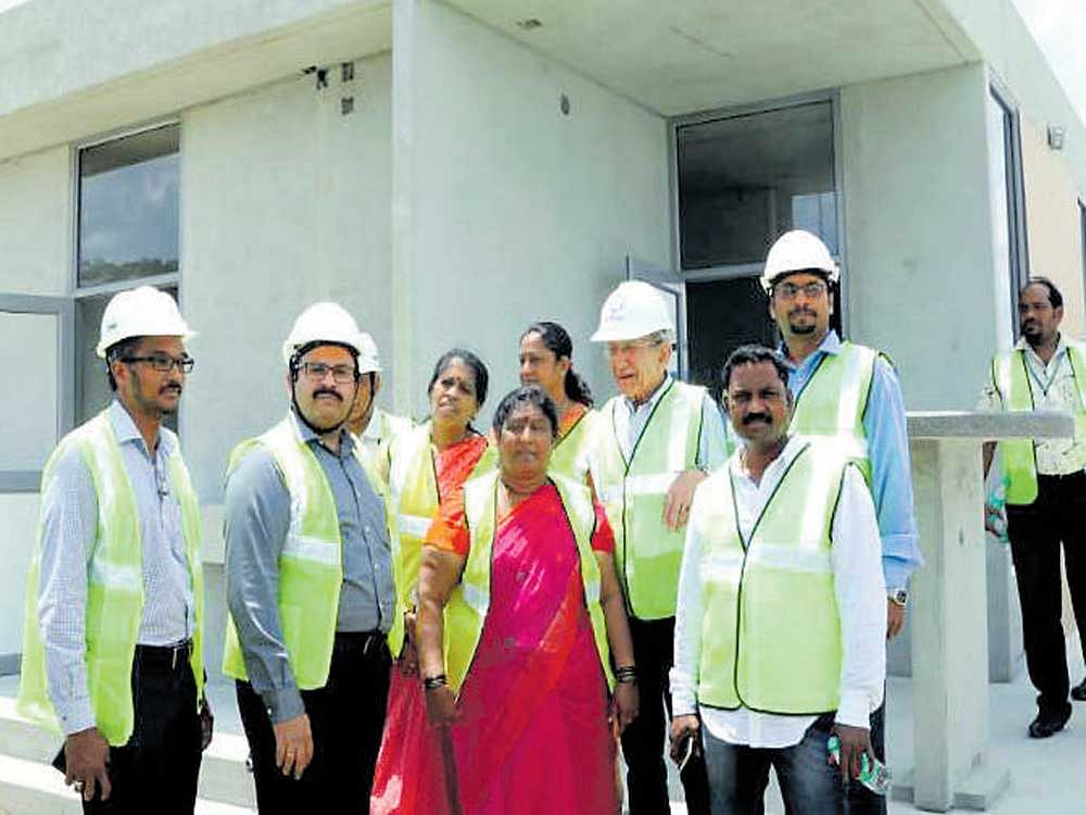 Mayor G&#8200;Padmavathi in front of a model of the Indira  Canteen at KEF Infrastructure, a multinational company, which is fabricating the canteens at Krishnagiri, Tamil Nadu.