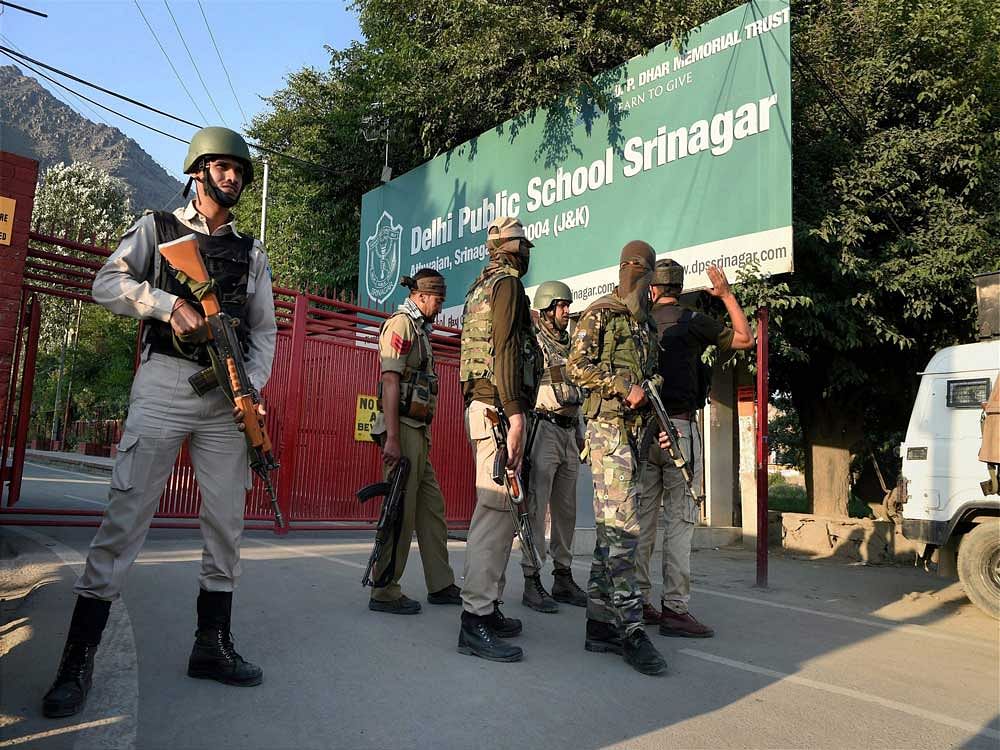 Special task force of police positioning out side a school during search operation after the CRPF vehicle was attacked by militants at Pantha Chowk in Srinagar on Saturday. A CRPF jawan was killed and another injured in attack. PTI Photo