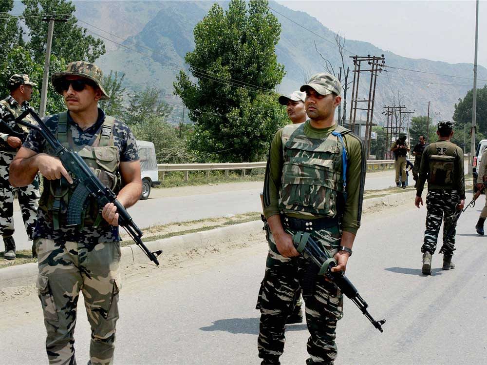 CRPF men take positions near Delhi Public School (DPS) during an encounter with the militants at Pantha Chowk in Srinagar on Sunday. PTI Photo
