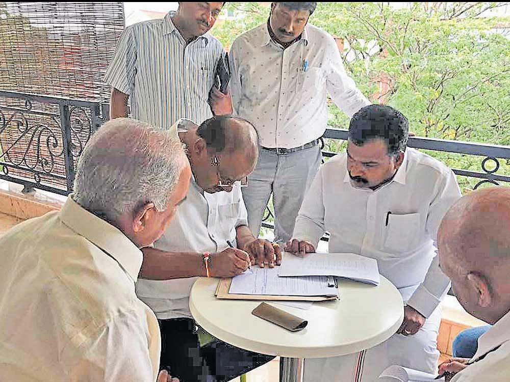 JD(S)&#8200;state president H&#8200;D&#8200;Kumaraswamy on Sunday signs the papers to propose the candidature of Meira Kumar for the Presidential election. Congress leaders N S Boseraju  and others are seen. dh photo