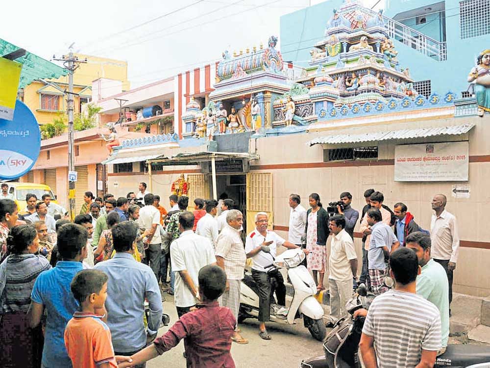 A crowd gathers in front of Renuka Yellamma temple at  Srinivasnagar, from where a gold chain adorning the deity was stolen on Monday morning. dh Photo