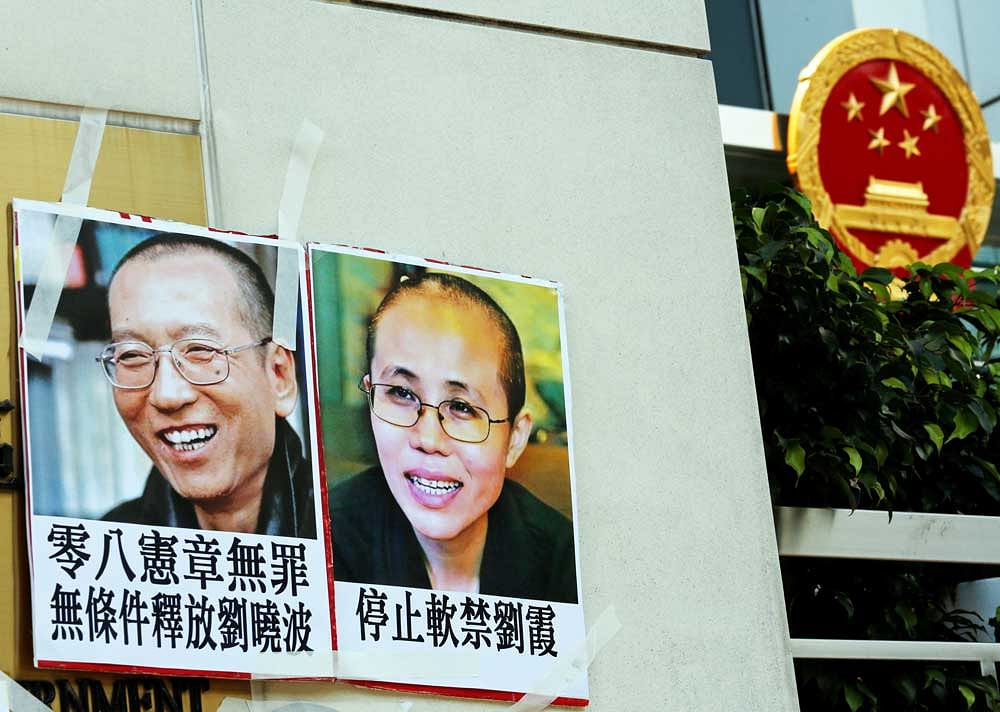 Photos of Chinese Nobel rights activist Liu Xiaobo (L) and wife Liu Xia are left by protesters outside China's Liaison Office in Hong Kong, China June 27, 2017. REUTERS