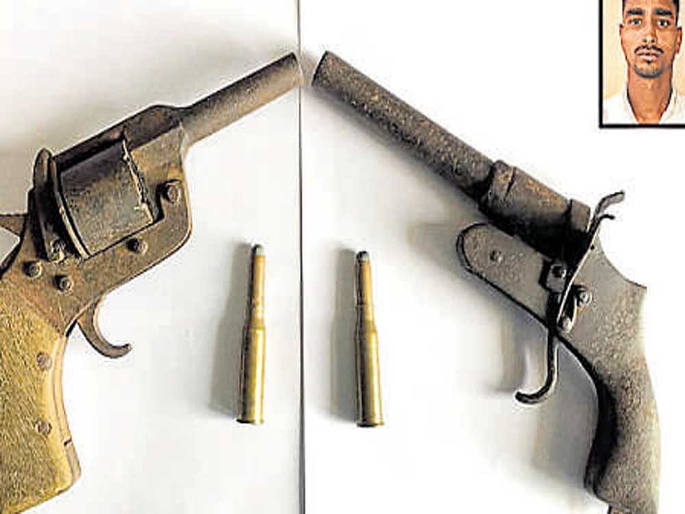 A countrymade pistol and revolver seized from Goutham Pandey (inset).
