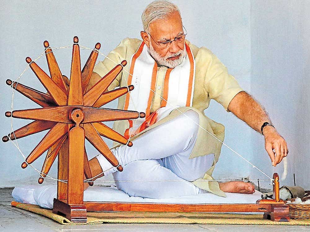 Prime Minister Narendra Modi spins cotton on a wheel during his visit to Gandhi Ashram in Ahmedabad on Thursday. Reuters Photo