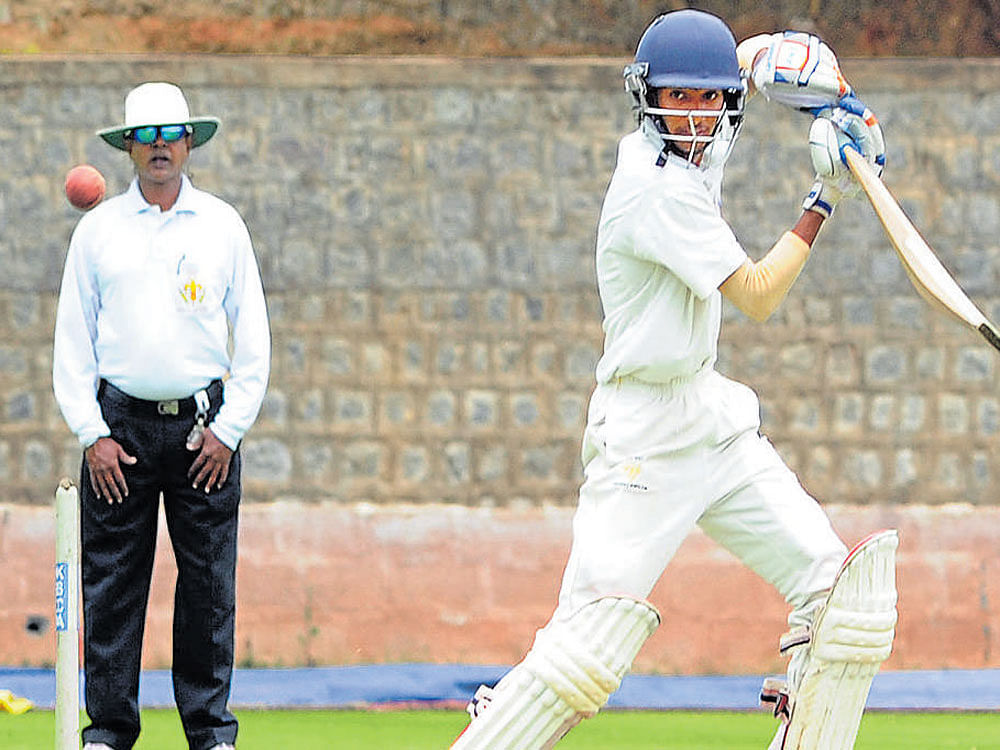 Driven Kishan S Bedare of Mofussil XI directs one to the fence en route his 105 against President's XI. DH Photo