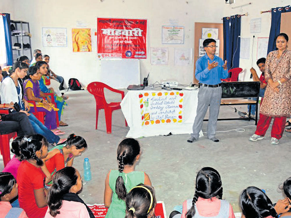 Amit Sarikwal explains to women and girls on menstrual hygiene in Lucknow.