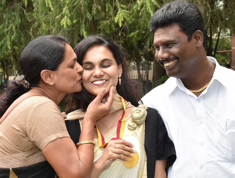 Vidhya Y, one of the toppers in MSc (digital society), gets a peck on the cheek from her mother Pushpa while her father Yella Reddy looks on at the convocation of the International Institute of Information Technology, Bangalore (IIITB), on Sunday. DH photo