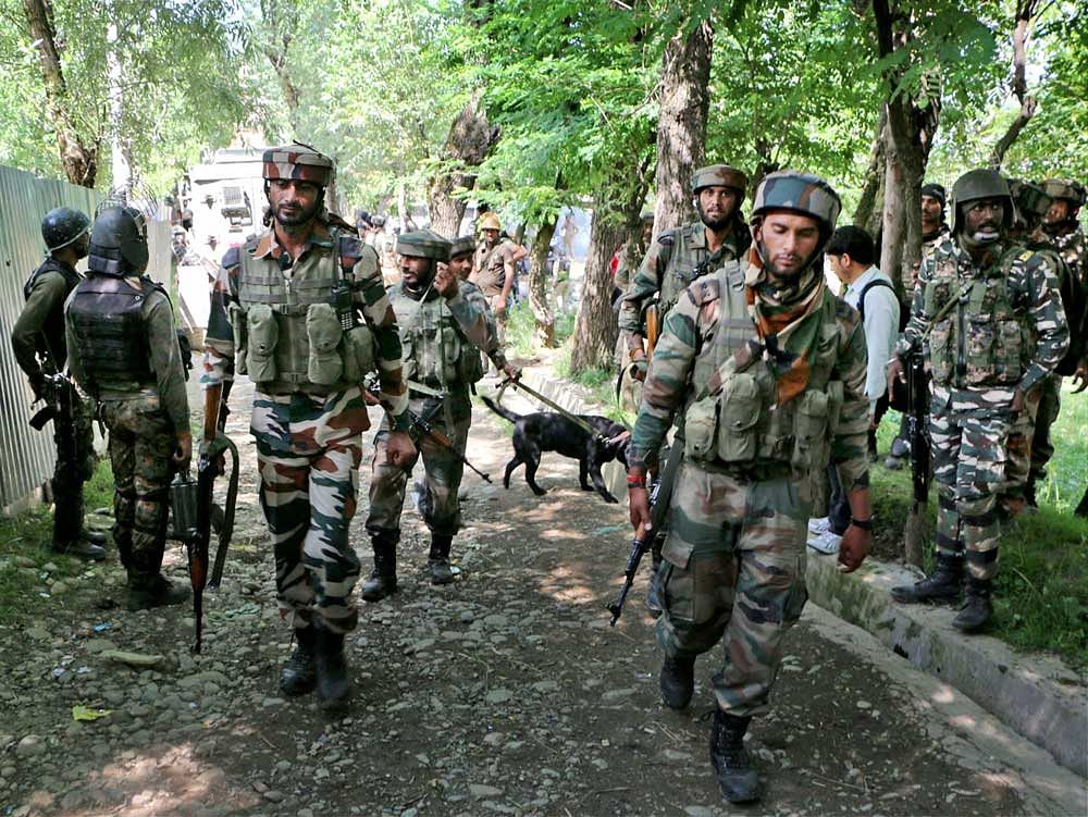 Army personnel move towards the house where militants were hiding during an encounter at Bamnoo in Pulwama district of south Kashmir on Monday. PTI Photo