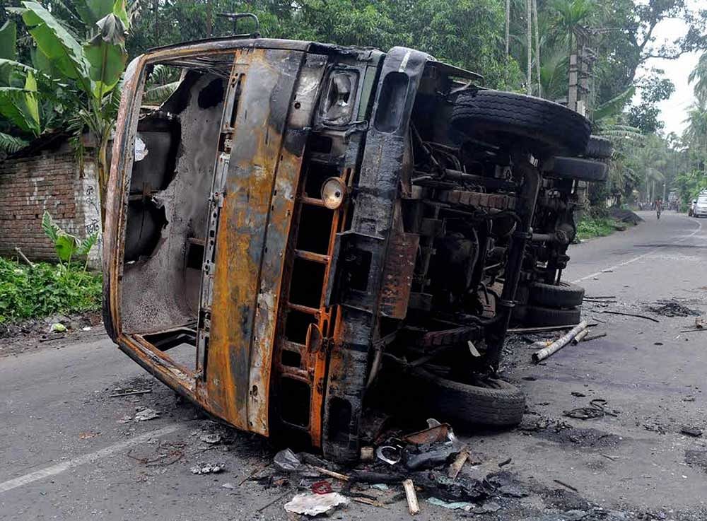 A burnt vehicle seen at a road after a communal riot at Baduria in North 24 Pargana district of West Bengal on Wednesday. PTI file Photo