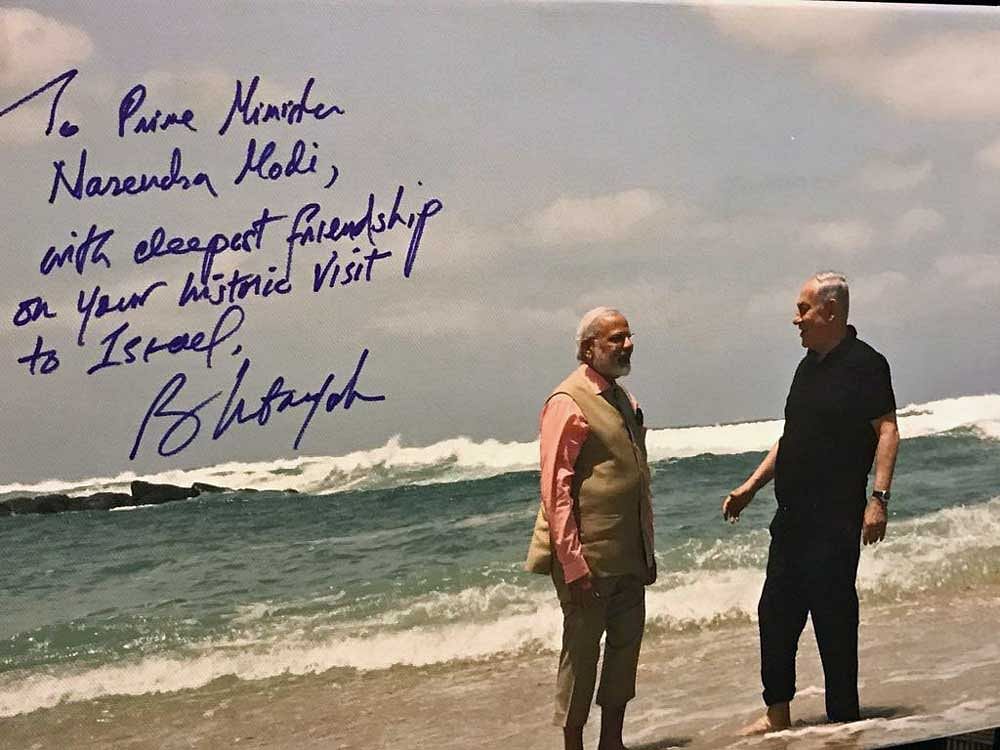 The picture, signed by the Israeli Prime Minister, shows Modi and Netanyahu strolling barefoot together at Olga beach in northern Israel. Coutesy: Twitter/ Benjamin Netanyahu