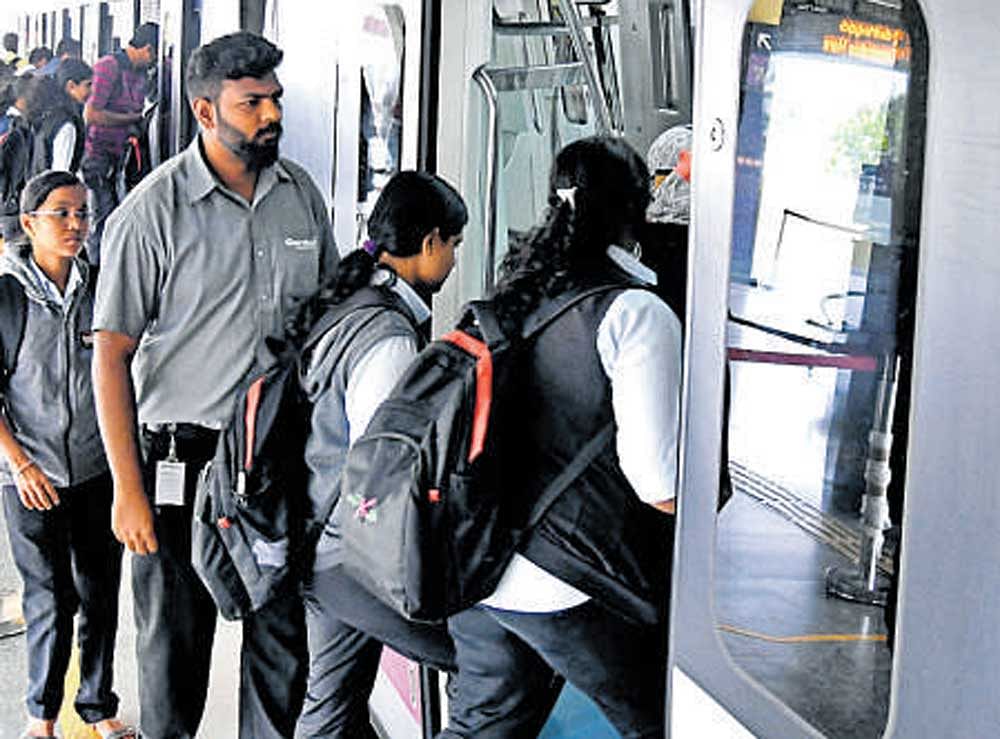Commuters board a Metro train after BMRCL staff called off the flash strike.