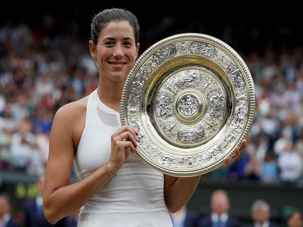 Spain's Garbine Muguruza holds the trophy after defeating Venus Williams of the United States in the Women's Singles final match on day twelve at the Wimbledon Tennis Championships in London. AP/PTI