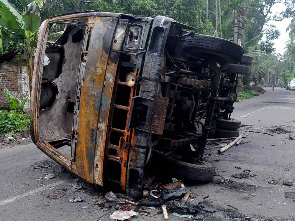 A burnt vehicle seen at a road after a communal riot at Baduria in North 24 Pargana district of West Bengal on Wednesday. PTI Photo