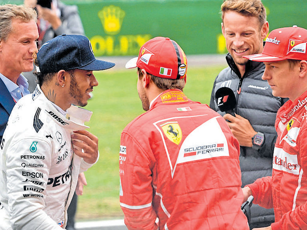 graceful Mercedes' Lewis Hamilton (left) is congratulated by Ferrari's Sebastian Vettal after claiming pole at Silverstone on Saturday while Kimi Raikkonen looks on. afp