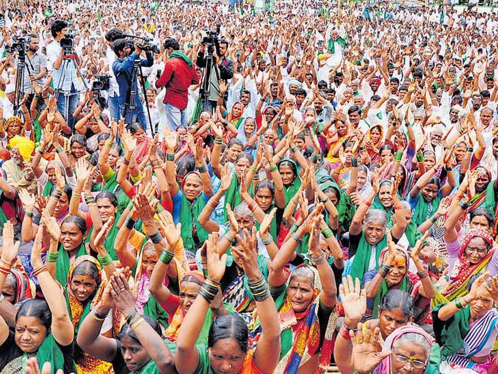 Participants clap in support of a resolution moved during the rally held to mark the second anniversary of the Mahadayi agitation at Naragund in Gadag district on Sunday. DH photo.