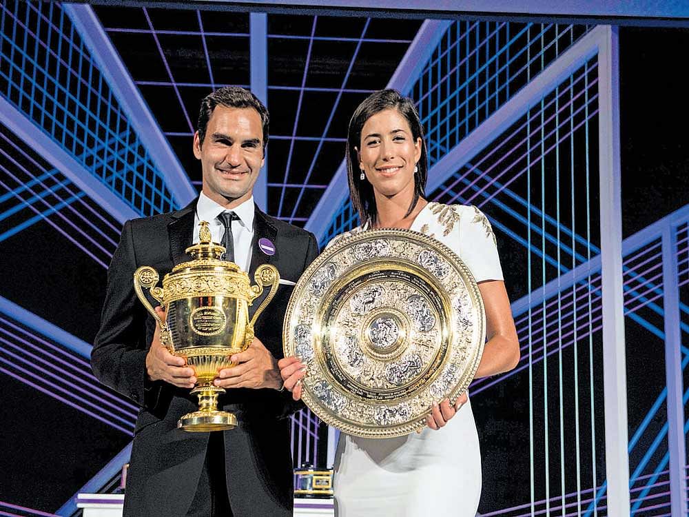 Men's champion Roger Federer and women's title winner Garbine Muguruza with their spoils at the Wimbledon ball on Sunday. AFP