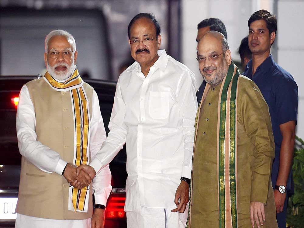 Union Minister M. Venkaiah Naidu is greeted by Prime Minister Narendra Modi as BJP President Amit Shah looks on, after he was announced as the BJP's Vice-Presidential candidate in New Delhi on Monday. PTI Photo