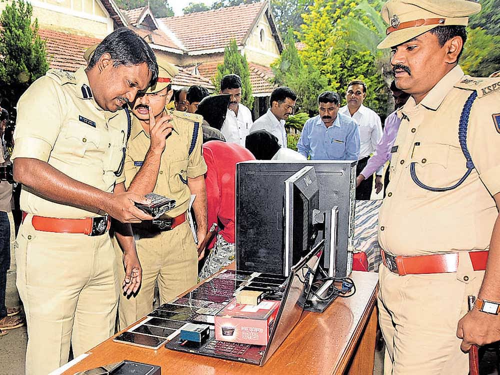 Police Commissioner Dr A Subramanyeshwara Rao inspects IMEI&#8200;number tampering machines and other items seized by the police in Mysuru, on Tuesday. DCPs Dr Vikram Amte, and Dr H T Shekar are seen. DH PHOTO