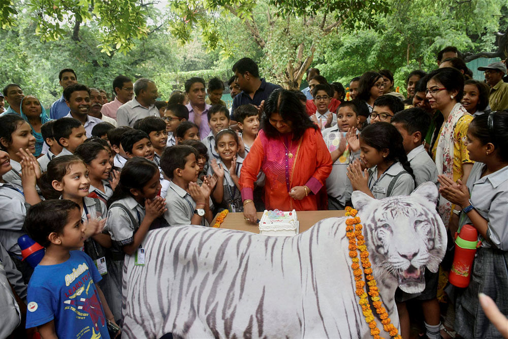 Renu Singh, director of the National Zoological Park, cuts a cake along with the school children to celebrate the 10th birthday of tiger 'Vijay' at the zoo in New Delhi on Thursday. PTI Photo