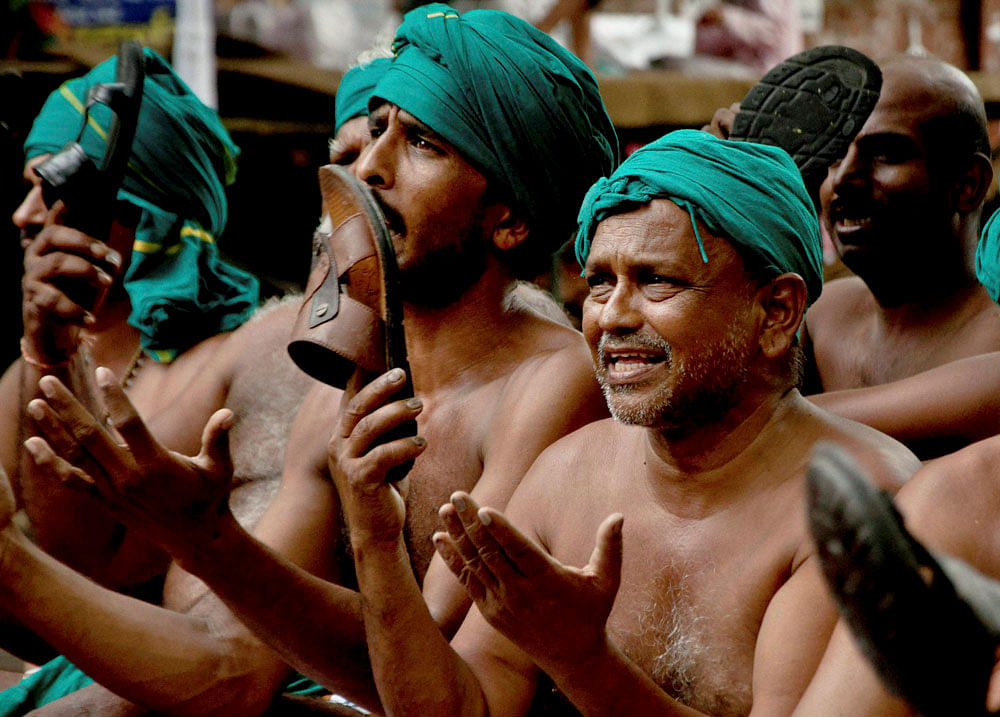 Tamil farmers hit their heads with footwears during their protest for loan waiver and drought-relief package, at Jantar Mantar in New Delhi on Thursday. PTI Photo