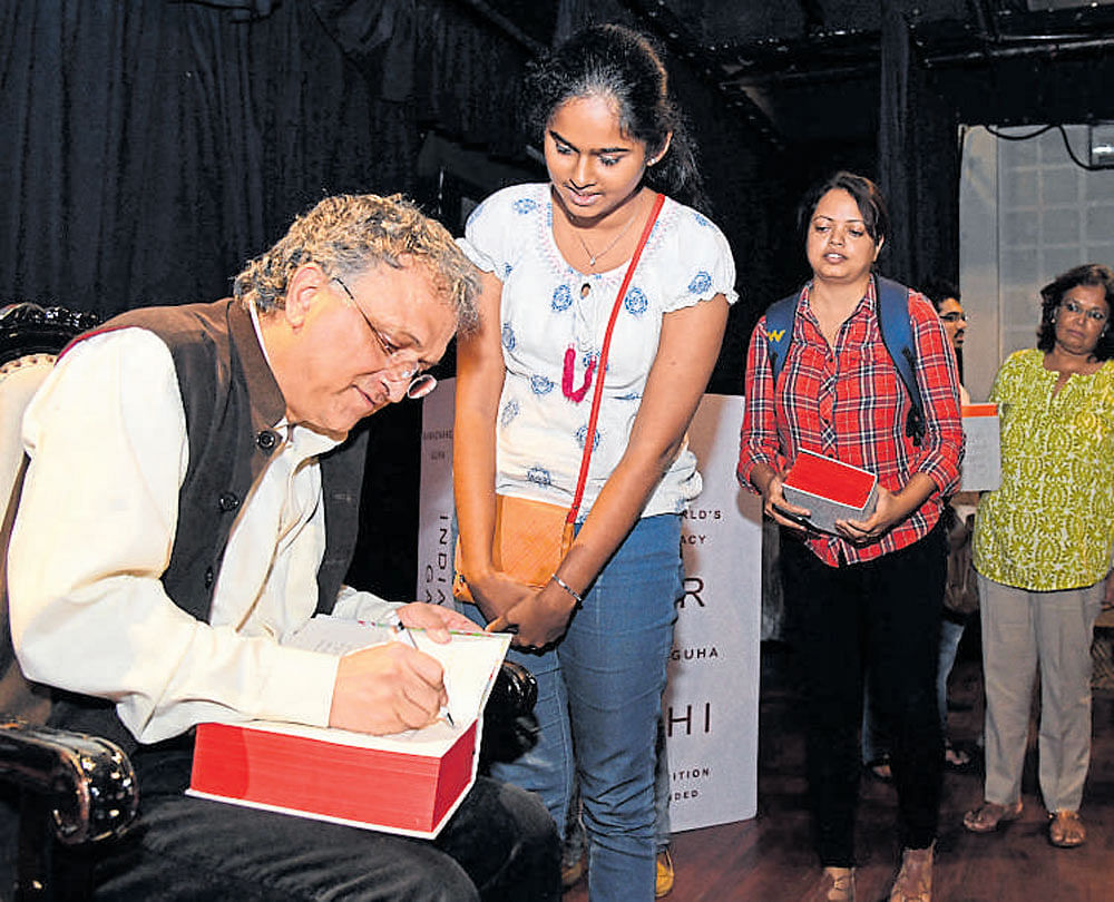 Historian Ramachandra Guha signs autographs on the 10th anniversary edition of his book 'India After Gandhi,' which was released on Friday. DH&#8200;Photo