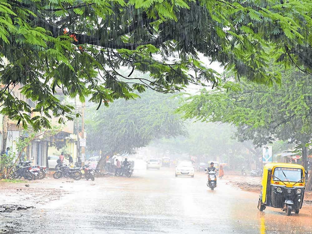 Motorists face a tough time at Siddeshwara Park road  in Hubballi after skies opened up on Friday. dh photo