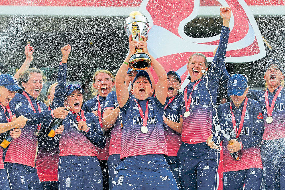 last laugh: England eves celebrate with the World Cup after beating India by nine runs in the final in London on  Sunday. reuters